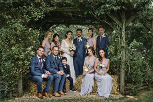 bridal party sitting on haystacks