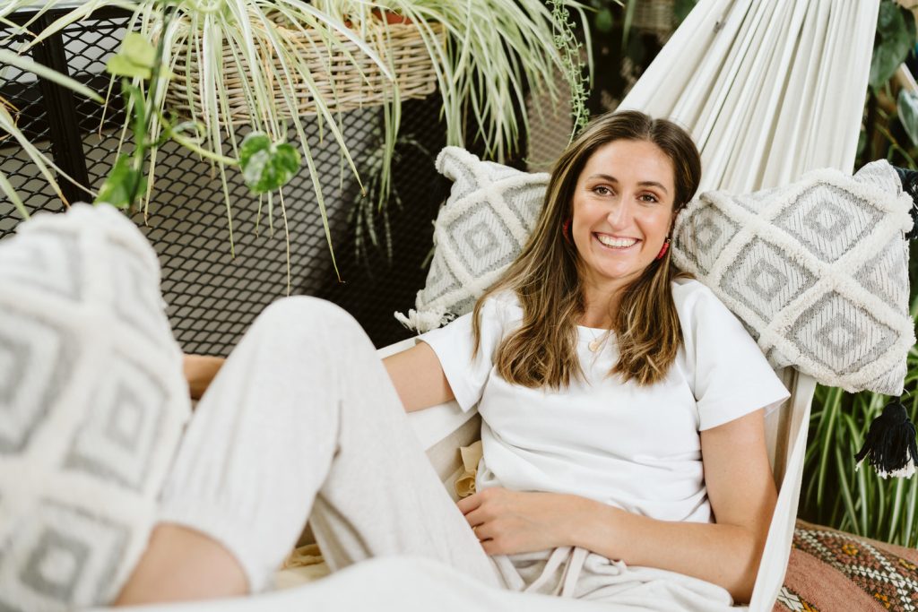 Brown haired woman sitting in macrame hammock - Karen Flower Brand Photography